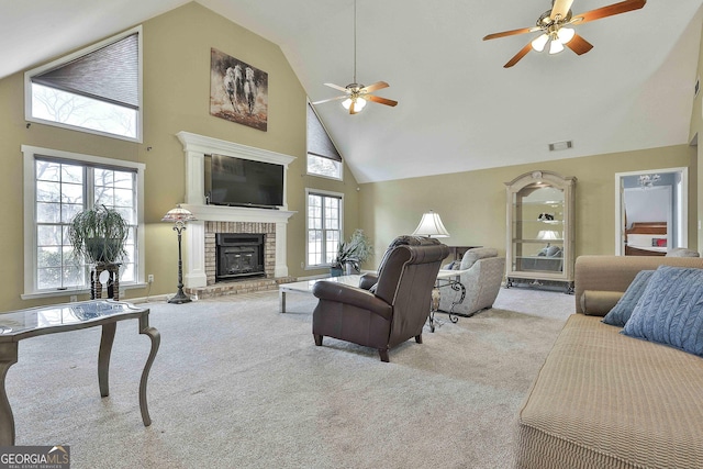 carpeted living room with ceiling fan, a fireplace, and high vaulted ceiling