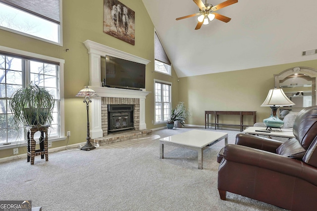 carpeted living room featuring a fireplace, high vaulted ceiling, plenty of natural light, and ceiling fan