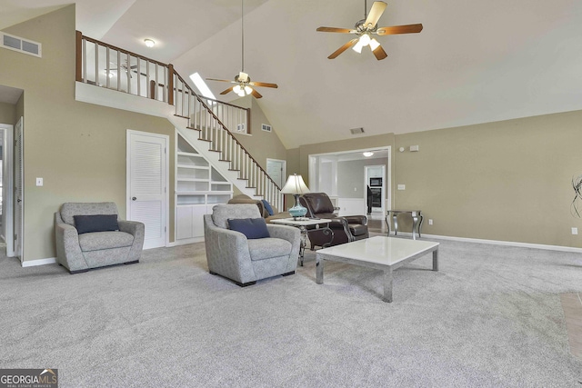 carpeted living room with ceiling fan and high vaulted ceiling