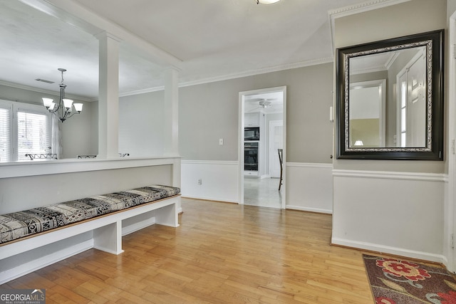 mudroom with crown molding, light hardwood / wood-style flooring, and an inviting chandelier