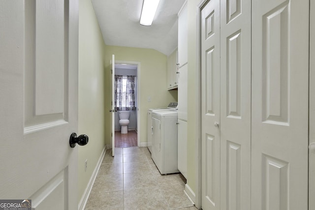 laundry room featuring washer and clothes dryer, cabinets, and light tile patterned floors