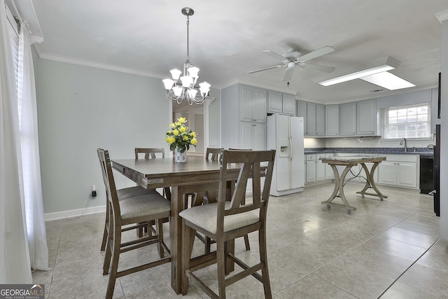 tiled dining room featuring ceiling fan with notable chandelier, crown molding, and sink