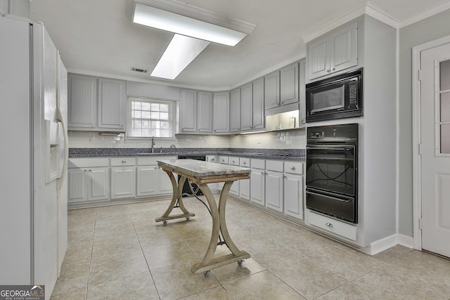 kitchen featuring black appliances, gray cabinets, and backsplash