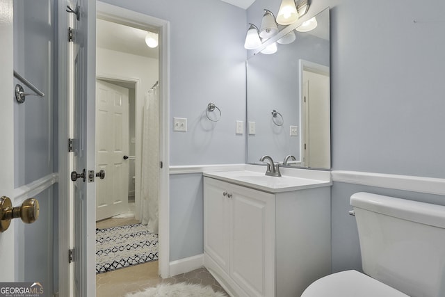 bathroom with tile patterned flooring, vanity, and toilet