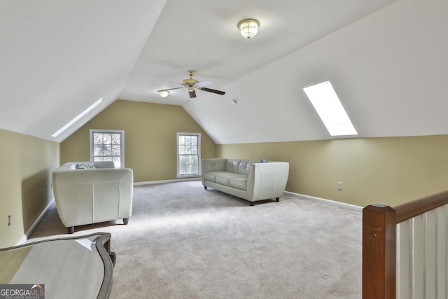 interior space with light colored carpet, lofted ceiling with skylight, and ceiling fan