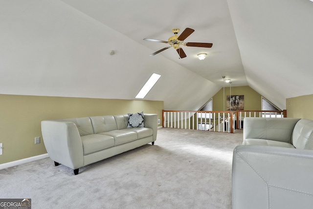 living room with ceiling fan, light colored carpet, and lofted ceiling with skylight