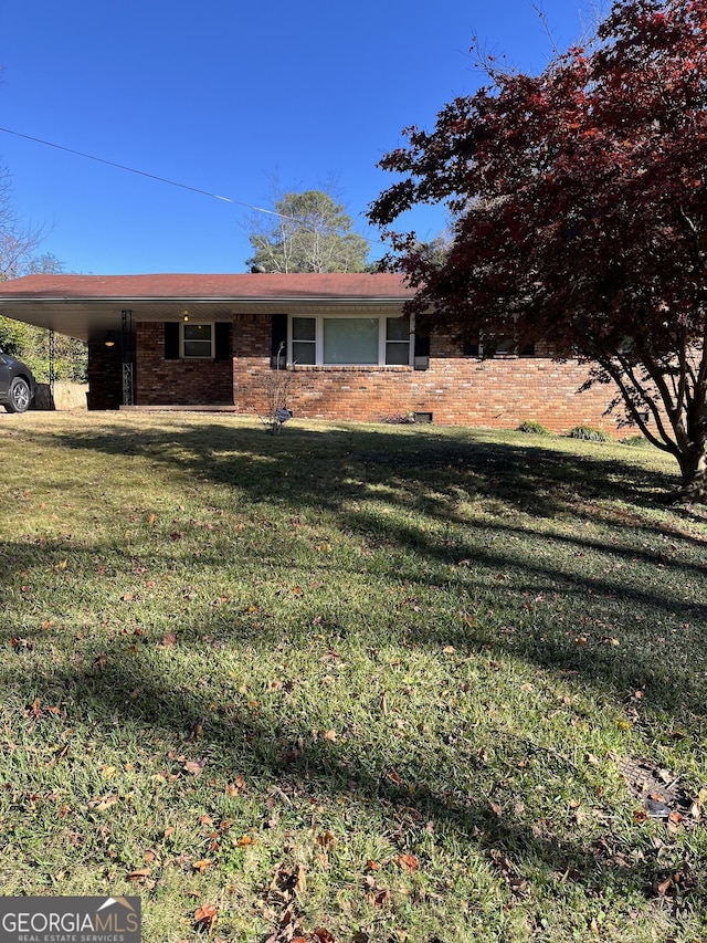 view of front of house with a carport and a front lawn