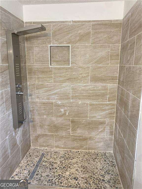 bathroom with a tile shower