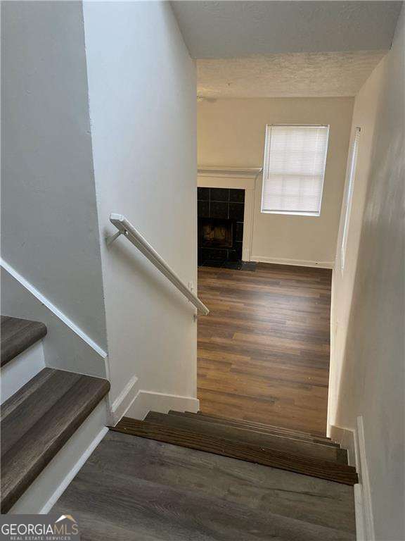 staircase featuring a fireplace and wood-type flooring