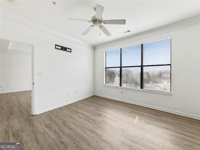 empty room with hardwood / wood-style floors, ceiling fan, and crown molding