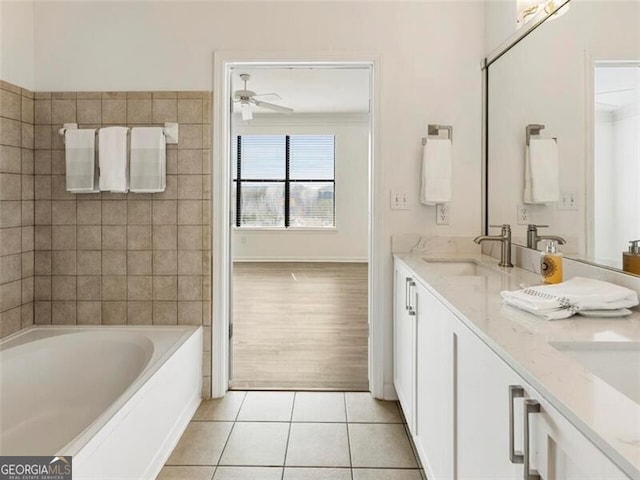 bathroom with tile patterned floors, vanity, ceiling fan, and a washtub