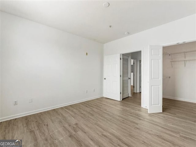 unfurnished bedroom featuring a closet and light hardwood / wood-style flooring