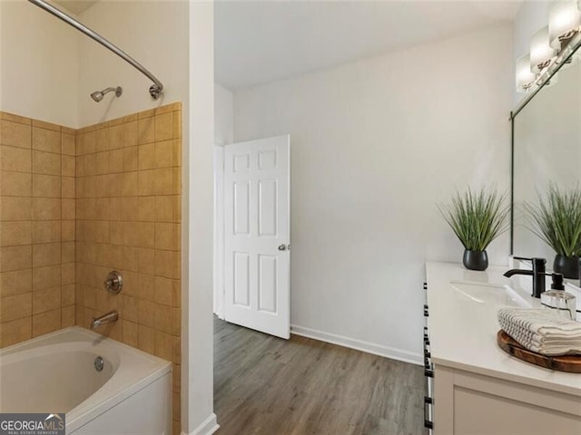 bathroom featuring vanity, wood-type flooring, and tiled shower / bath