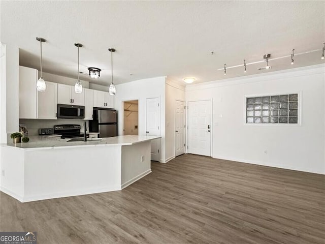 kitchen featuring white cabinetry, sink, hanging light fixtures, kitchen peninsula, and appliances with stainless steel finishes