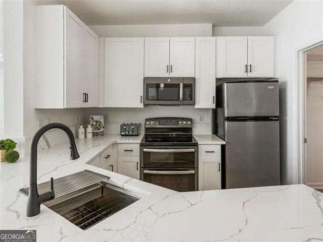 kitchen featuring white cabinets, sink, and appliances with stainless steel finishes