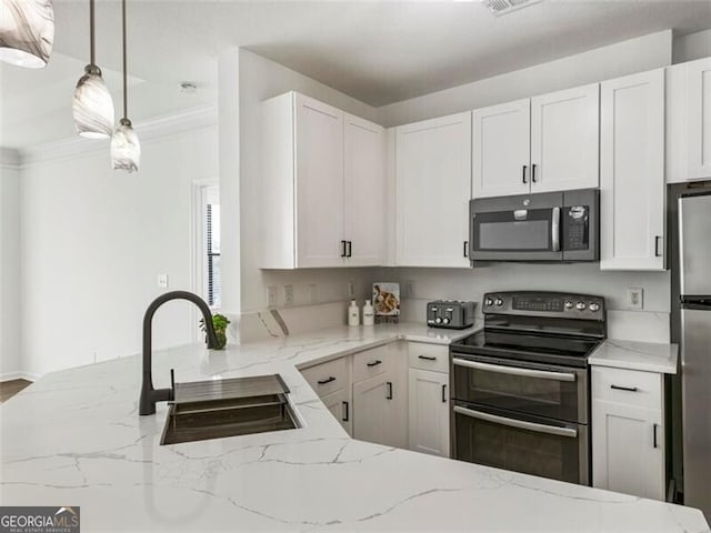 kitchen with light stone counters, stainless steel appliances, sink, white cabinetry, and hanging light fixtures