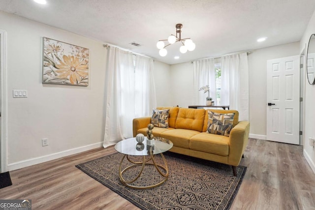 living room featuring a chandelier, a textured ceiling, and hardwood / wood-style flooring