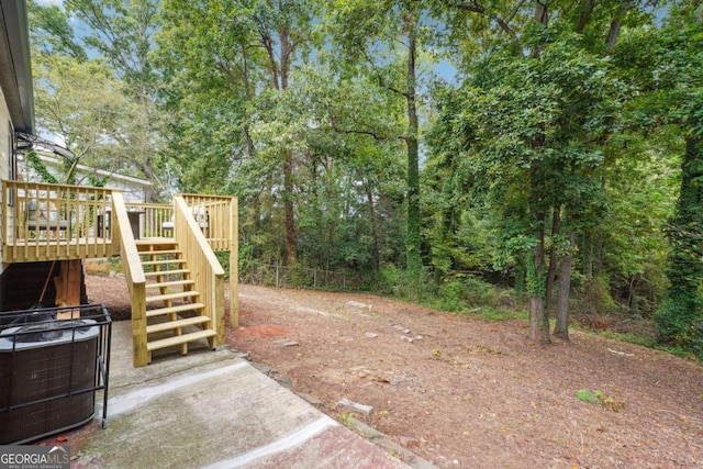 view of yard featuring a wooden deck and central air condition unit