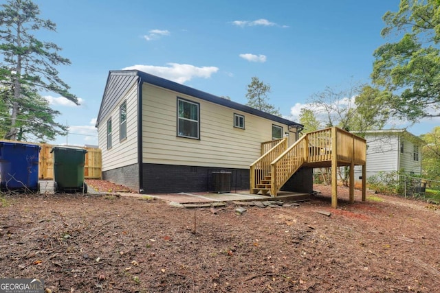 rear view of house with cooling unit and a wooden deck