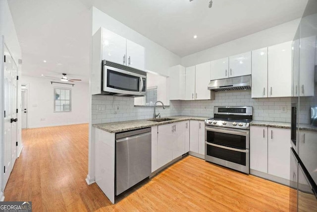 kitchen with stainless steel appliances, light hardwood / wood-style floors, white cabinets, ceiling fan, and sink