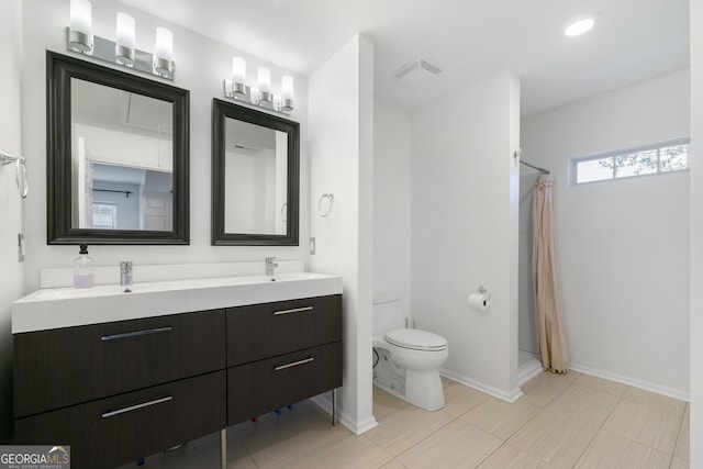 bathroom featuring toilet, a shower with shower curtain, and vanity