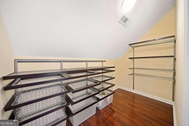 spacious closet featuring lofted ceiling and dark hardwood / wood-style floors