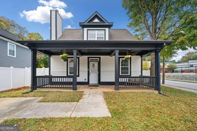 bungalow-style home featuring ceiling fan, a porch, and a front lawn