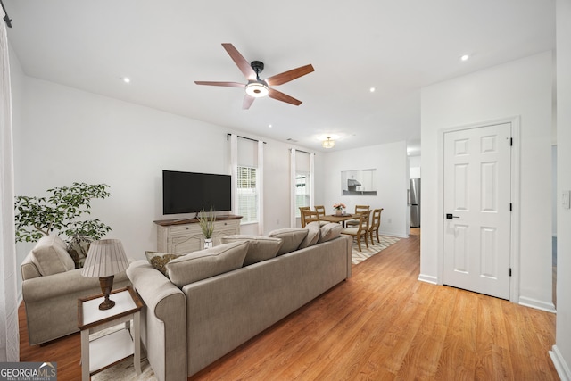 living room with ceiling fan and light hardwood / wood-style flooring