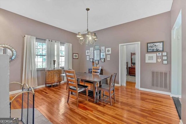 dining room with light wood-style floors, visible vents, a notable chandelier, and baseboards