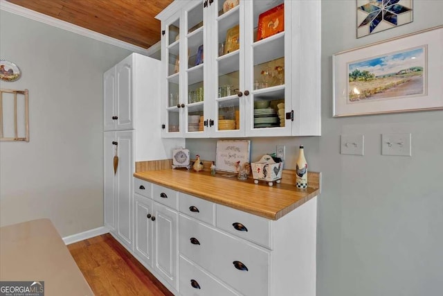 bar with ornamental molding, wood ceiling, baseboards, and wood finished floors