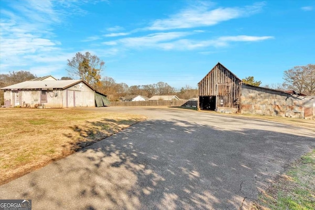 view of street with aphalt driveway and a barn