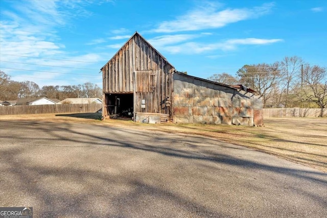 view of outdoor structure featuring fence and an outbuilding