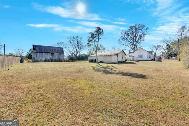 view of yard featuring fence, an outbuilding, and an outdoor structure