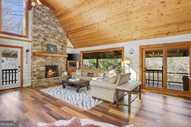 living room with hardwood / wood-style flooring, high vaulted ceiling, wooden ceiling, and wood walls