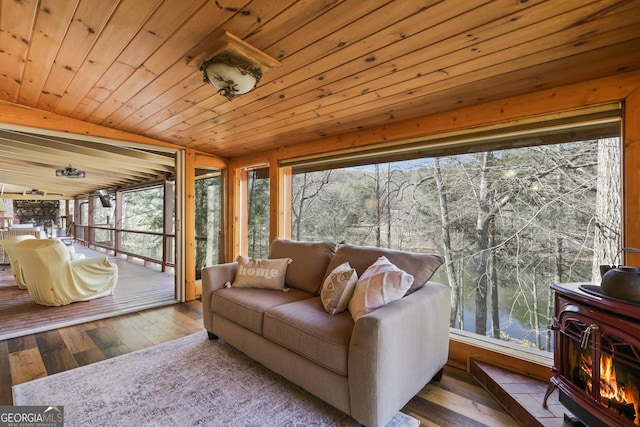 sunroom / solarium with a wood stove, a wealth of natural light, wooden ceiling, lofted ceiling, and a water view