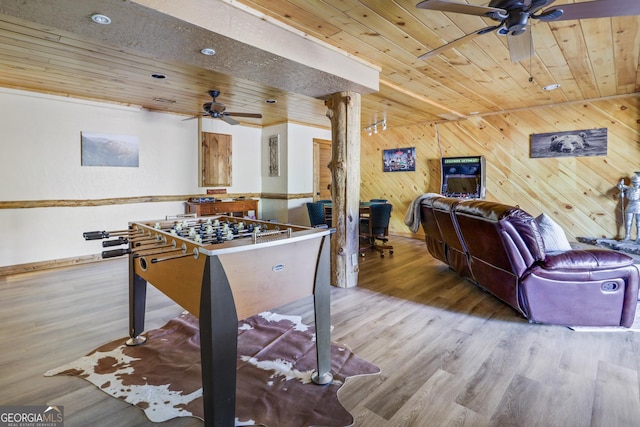 rec room with ceiling fan, wood walls, light wood-type flooring, and wooden ceiling