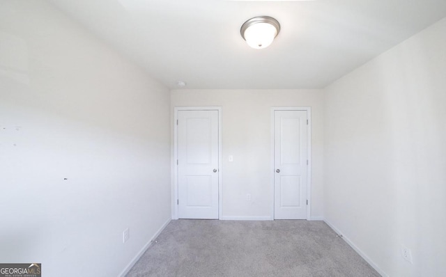 unfurnished bedroom with light carpet and a closet