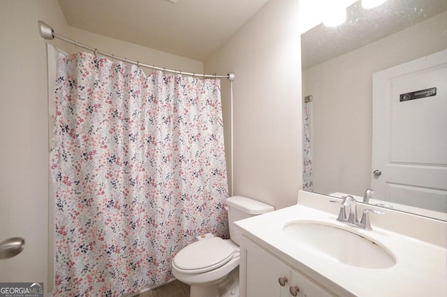 bathroom featuring a shower with curtain, vanity, and toilet