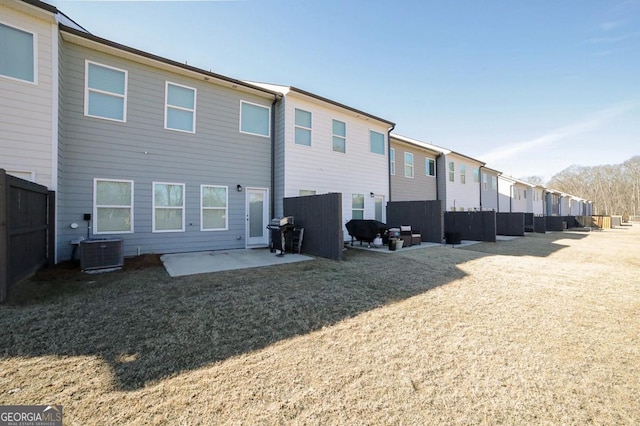 rear view of property with a patio, cooling unit, and a lawn