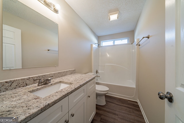 full bathroom with hardwood / wood-style floors, a textured ceiling, toilet, shower / washtub combination, and vanity