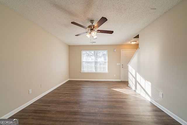 spare room featuring dark hardwood / wood-style floors, ceiling fan, and a textured ceiling