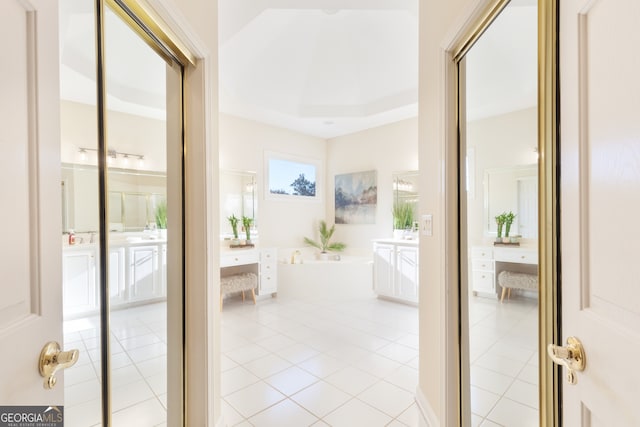 interior space featuring light tile patterned floors and a tray ceiling