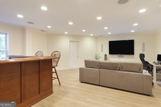 living room with light wood-type flooring and ornamental molding