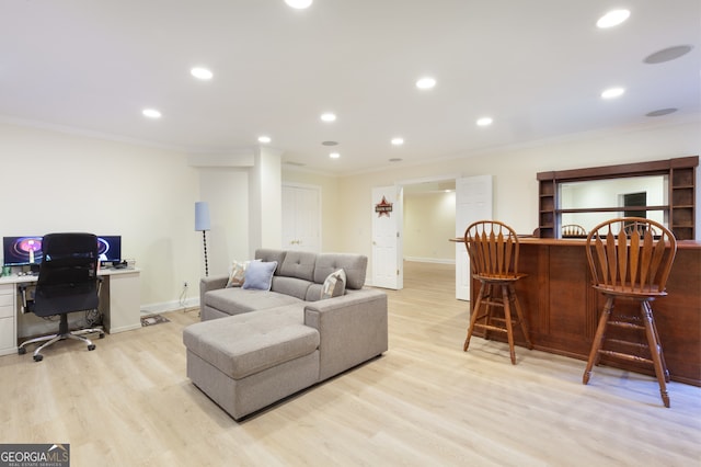 living room featuring crown molding, light hardwood / wood-style flooring, and indoor bar