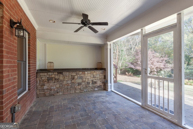 unfurnished sunroom with ceiling fan