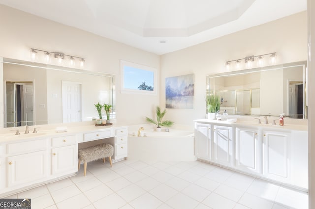 bathroom with tile patterned floors, vanity, a raised ceiling, and independent shower and bath