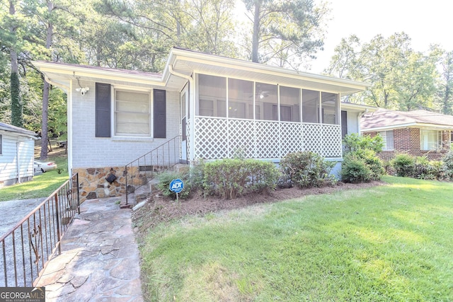 view of front of home featuring a front yard and a sunroom