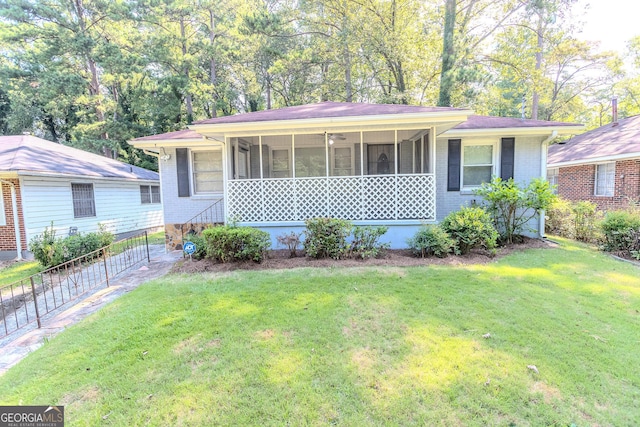 view of front facade with a front yard and a sunroom