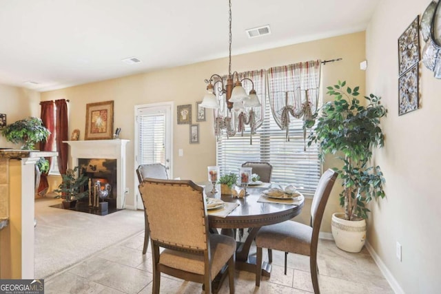 dining area with a chandelier, a fireplace with flush hearth, and baseboards