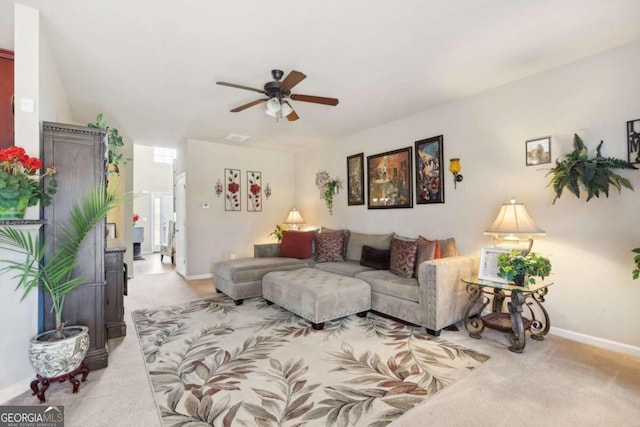 living room featuring ceiling fan, light colored carpet, and baseboards
